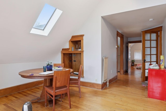 3205 Grand Ave S, Minneapolis, MN 55408 - dining area with a skylight, vaulted ceiling, light wood-style floors, and baseboards
