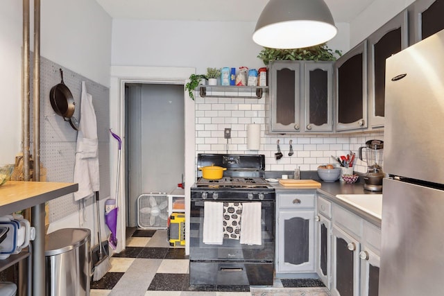3205 Grand Ave S, Minneapolis, MN 55408 - kitchen featuring freestanding refrigerator, black gas range, tasteful backsplash, tile patterned floors, and light countertops
