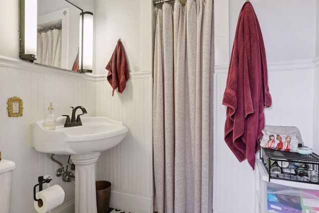 3205 Grand Ave S, Minneapolis, MN 55408 - bathroom featuring a decorative wall, toilet, wainscoting, and curtained shower