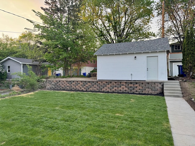 view of green lawn featuring an outbuilding