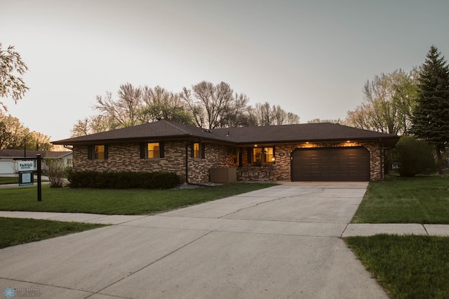 view of front of home with an attached garage, driveway, and a front lawn