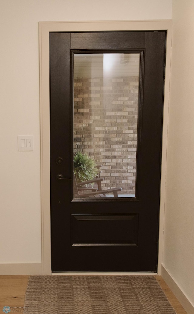 entryway featuring baseboards and wood finished floors