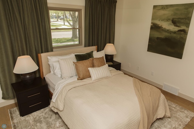 bedroom with wood finished floors and baseboards