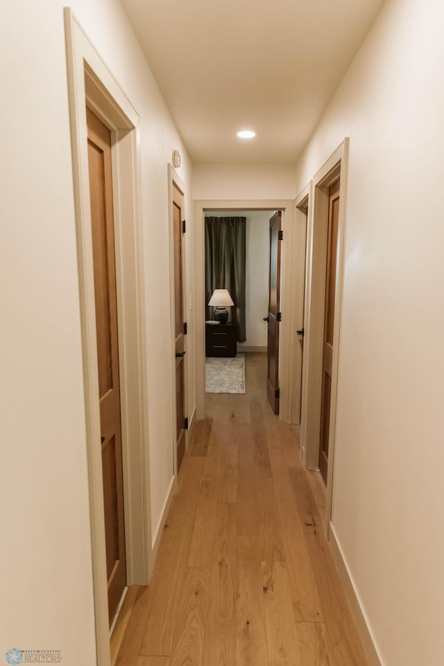 hall featuring light wood-style flooring and recessed lighting