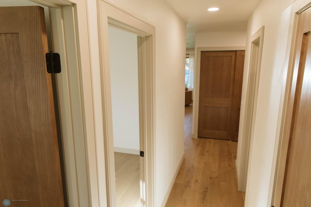 hall with light wood finished floors and recessed lighting