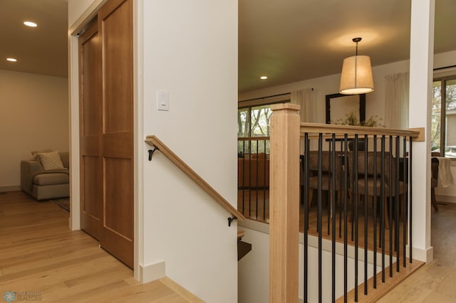 stairway featuring wood finished floors, recessed lighting, and baseboards