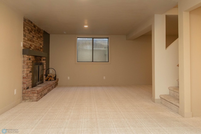 unfurnished living room featuring carpet, a brick fireplace, stairway, and recessed lighting