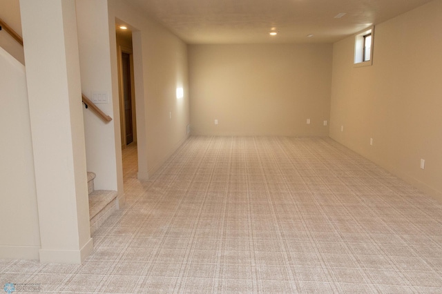 basement featuring light carpet, recessed lighting, and stairway