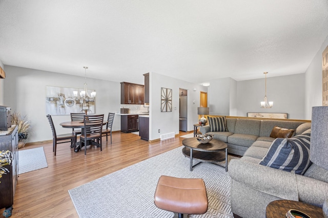 living area with a chandelier and light wood-style flooring