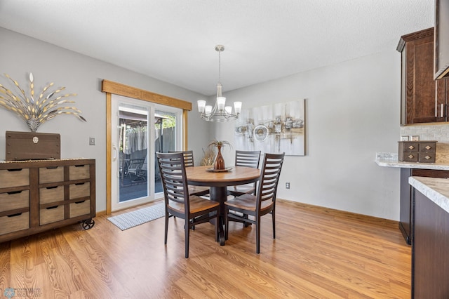 dining area with a chandelier and light wood-style flooring