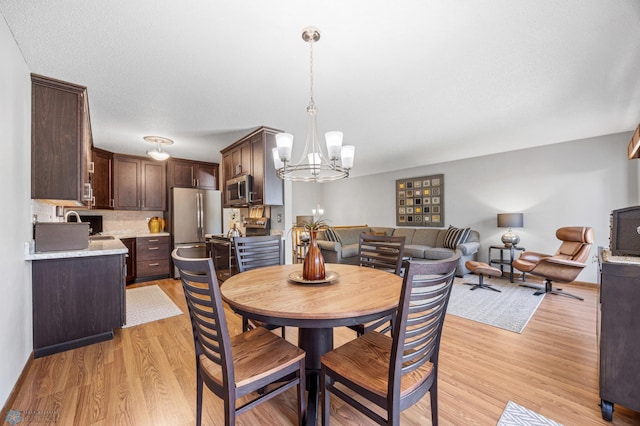 dining space with a chandelier and light wood finished floors