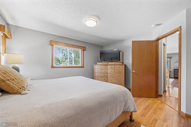 bedroom featuring light wood-style flooring and a textured ceiling