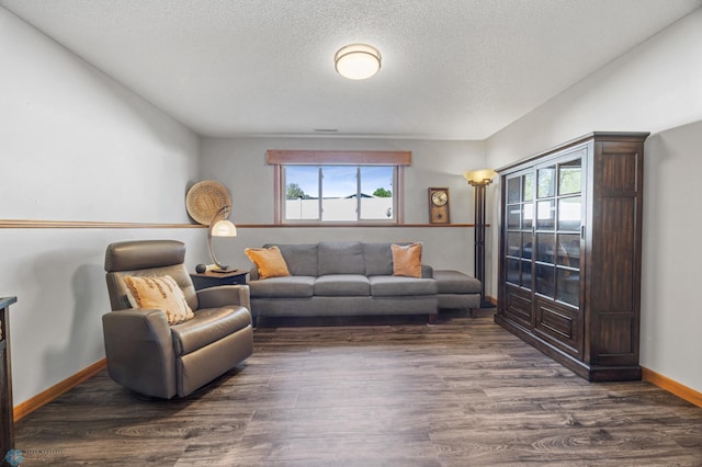 living room featuring plenty of natural light, a textured ceiling, dark wood finished floors, and baseboards