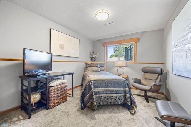 bedroom featuring carpet flooring, baseboards, and a textured ceiling