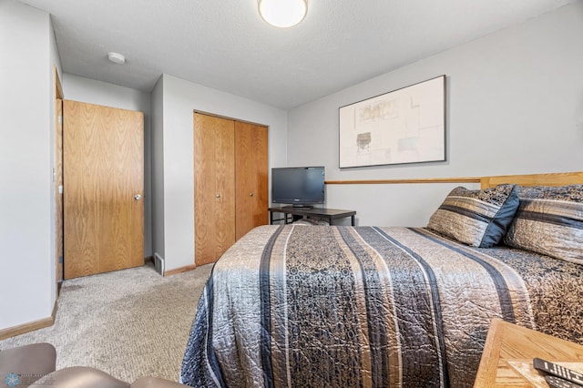 carpeted bedroom with a closet and baseboards