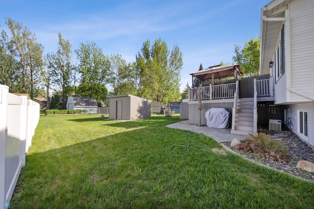 view of yard with a storage shed, a gazebo, an outdoor structure, stairs, and central AC