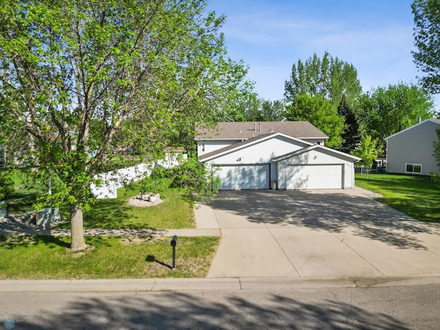 view of front of house with concrete driveway, a front lawn, and an attached garage