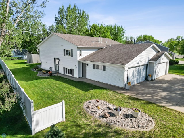 back of house featuring a garage, driveway, and a shingled roof