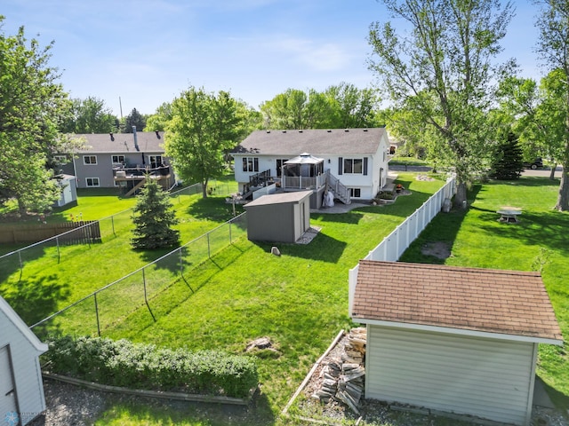 back of property featuring a wooden deck, stairway, a storage shed, and an outbuilding