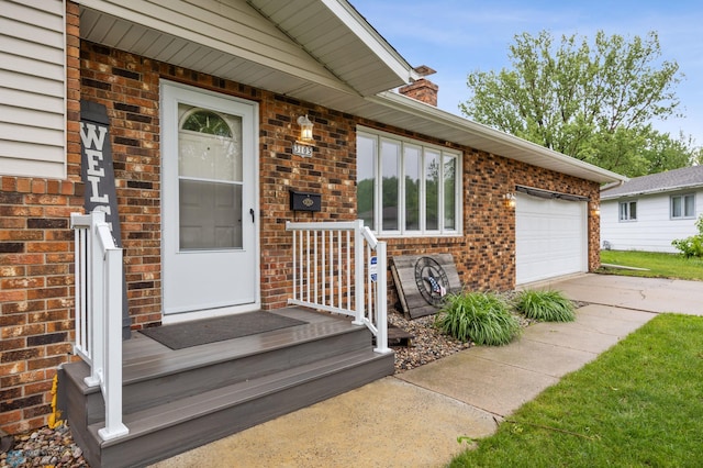 3105 Edgewood Dr N, Fargo, ND 58102 - view of exterior entry with brick siding, a chimney, concrete driveway, and an attached garage
