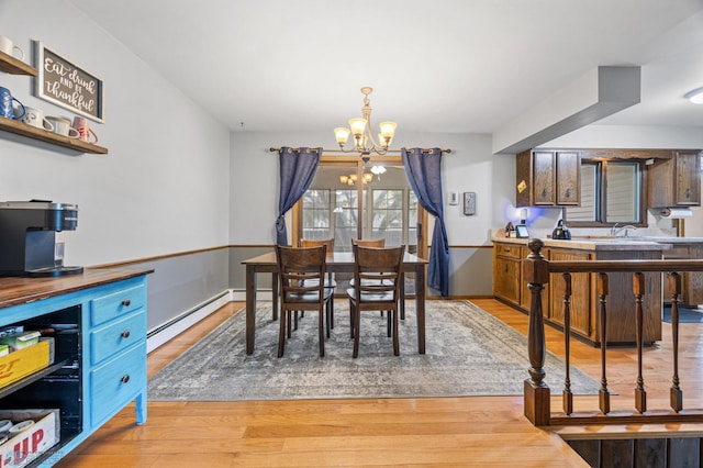 3105 Edgewood Dr N, Fargo, ND 58102 - dining area featuring a chandelier, baseboard heating, and light wood-style floors