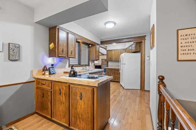 3105 Edgewood Dr N, Fargo, ND 58102 - kitchen with white appliances, brown cabinetry, a peninsula, light wood-style flooring, and a sink