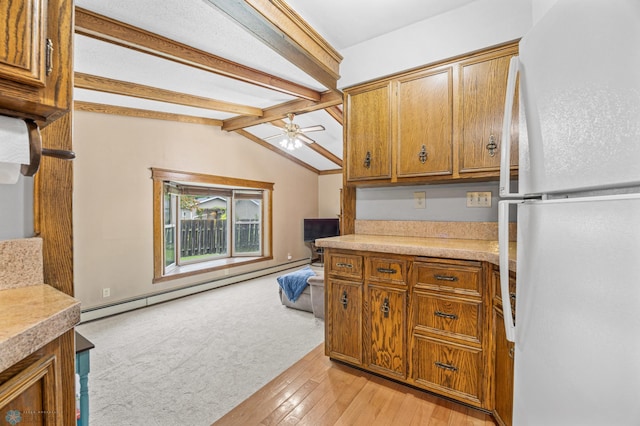 3105 Edgewood Dr N, Fargo, ND 58102 - kitchen featuring freestanding refrigerator, brown cabinetry, baseboard heating, ceiling fan, and light countertops