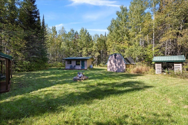 10397 Johnson Rd, Orr, MN 55771 - view of grassy yard with a storage unit, an outbuilding, and a wooded view