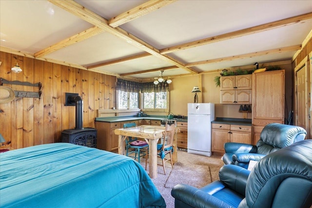 10397 Johnson Rd, Orr, MN 55771 - bedroom with freestanding refrigerator, light carpet, wooden walls, beam ceiling, and a wood stove