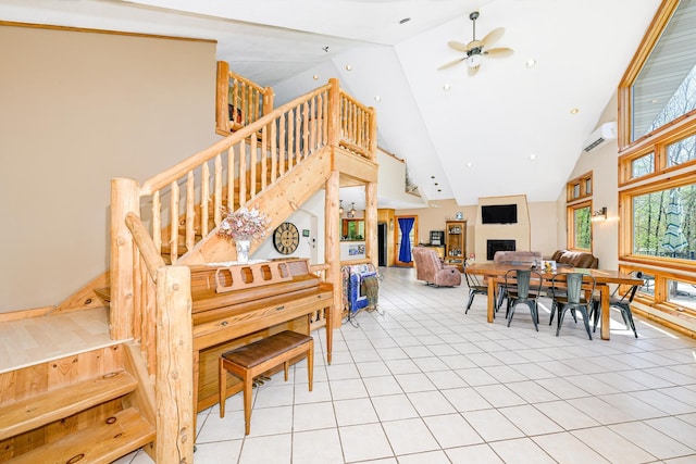 3818 Erickson Rd, Barnum, MN 55707 - dining space featuring high vaulted ceiling, stairs, a fireplace, light tile patterned floors, and ceiling fan