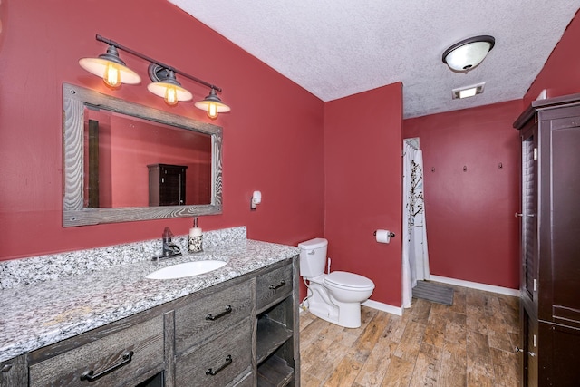 3818 Erickson Rd, Barnum, MN 55707 - bathroom featuring a textured ceiling, vanity, toilet, baseboards, and wood finished floors