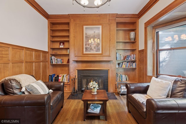 46 Crocus Pl, Saint Paul, MN 55102 - living area featuring built in features, ornamental molding, wood finished floors, a fireplace with flush hearth, and a wainscoted wall