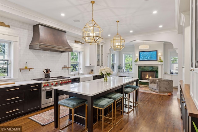 46 Crocus Pl, Saint Paul, MN 55102 - kitchen featuring custom exhaust hood, range with two ovens, light countertops, a breakfast bar, and decorative backsplash