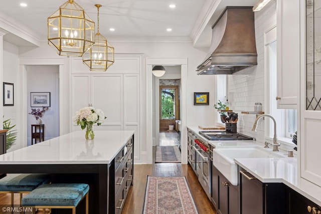 46 Crocus Pl, Saint Paul, MN 55102 - kitchen with custom exhaust hood, a chandelier, light countertops, dark wood-type flooring, and ornamental molding