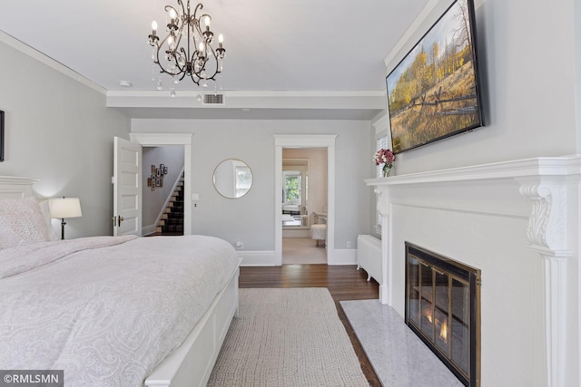 46 Crocus Pl, Saint Paul, MN 55102 - bedroom with a fireplace with flush hearth, wood finished floors, a chandelier, and baseboards