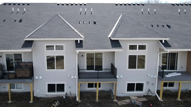 back of house with roof with shingles