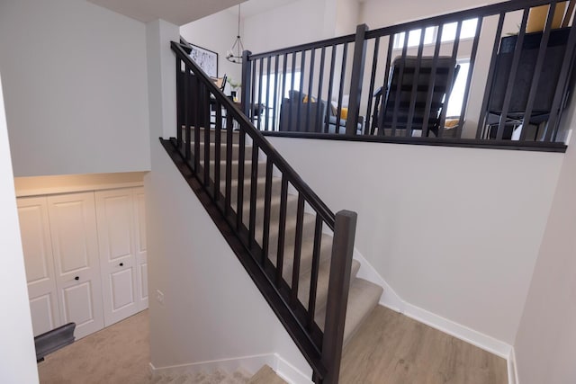 stairs with baseboards, plenty of natural light, and wood finished floors