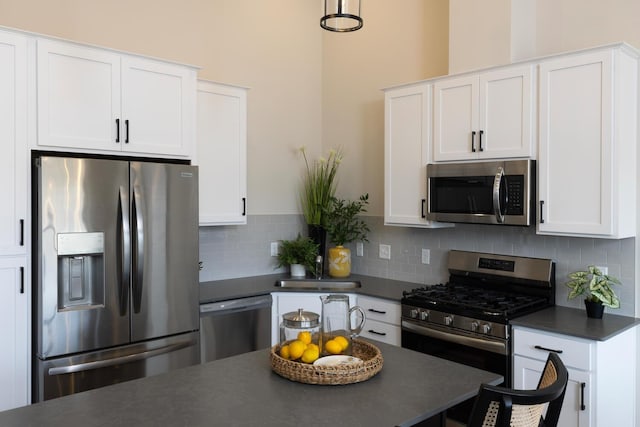 kitchen featuring appliances with stainless steel finishes, dark countertops, and white cabinetry