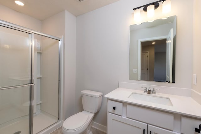 full bathroom featuring toilet, a stall shower, and vanity