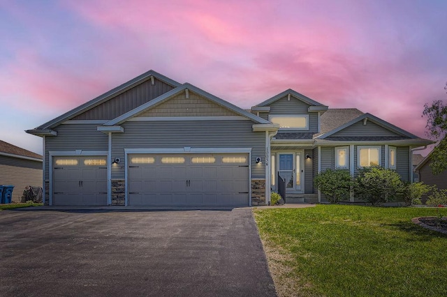 10034 191st Ave NW, Elk River, MN 55330 - view of front facade featuring driveway, a front lawn, an attached garage, and stone siding
