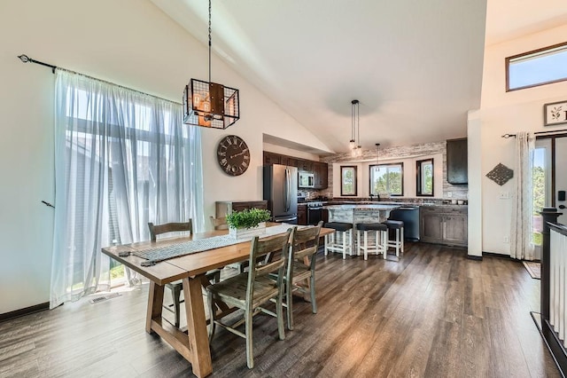 10034 191st Ave NW, Elk River, MN 55330 - dining area featuring high vaulted ceiling, a chandelier, dark wood-style floors, and plenty of natural light
