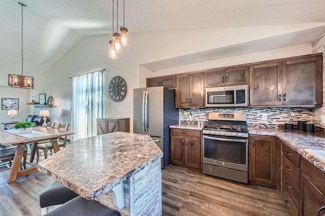 10034 191st Ave NW, Elk River, MN 55330 - kitchen featuring appliances with stainless steel finishes, vaulted ceiling, dark wood finished floors, a chandelier, and decorative backsplash
