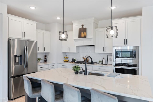 10082 Arrowwood Trl, Woodbury, MN 55129 - kitchen featuring appliances with stainless steel finishes, backsplash, white cabinetry, a breakfast bar area, and recessed lighting