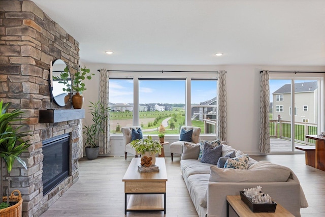 10082 Arrowwood Trl, Woodbury, MN 55129 - living area with a stone fireplace, healthy amount of natural light, and wood finished floors