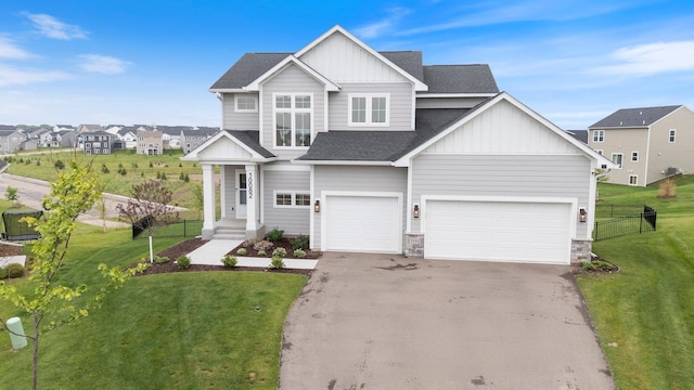 10082 Arrowwood Trl, Woodbury, MN 55129 - view of front of property with board and batten siding, driveway, roof with shingles, and stone siding