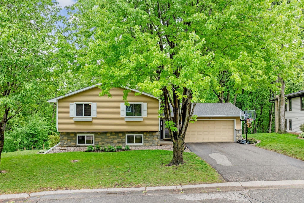 112115 Haering Cir, Chaska, MN 55315 - split level home with asphalt driveway, a front lawn, and a garage