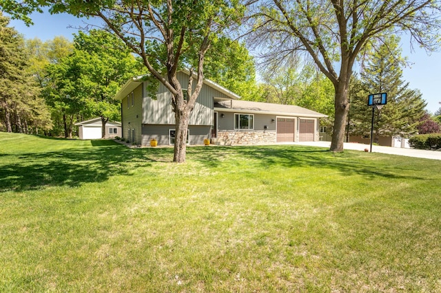 2510 Conifer Ave, Alexandria, MN 56308 - back of house featuring a garage, concrete driveway, a lawn, board and batten siding, and stone siding