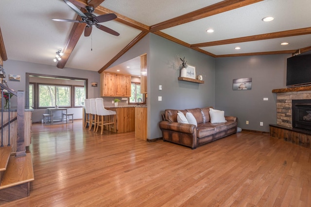 2510 Conifer Ave, Alexandria, MN 56308 - living room featuring light wood-style flooring, a ceiling fan, recessed lighting, a stone fireplace, and baseboards