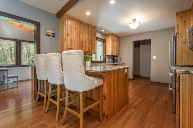 2510 Conifer Ave, Alexandria, MN 56308 - kitchen with a peninsula, a sink, light wood finished floors, a kitchen breakfast bar, and recessed lighting