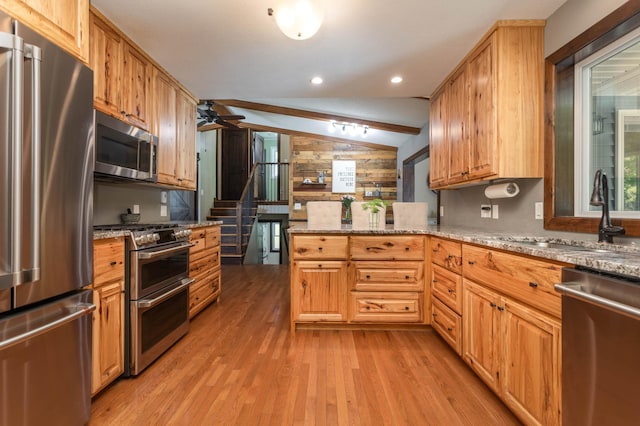 2510 Conifer Ave, Alexandria, MN 56308 - kitchen featuring appliances with stainless steel finishes, a sink, light wood-type flooring, lofted ceiling, and ceiling fan